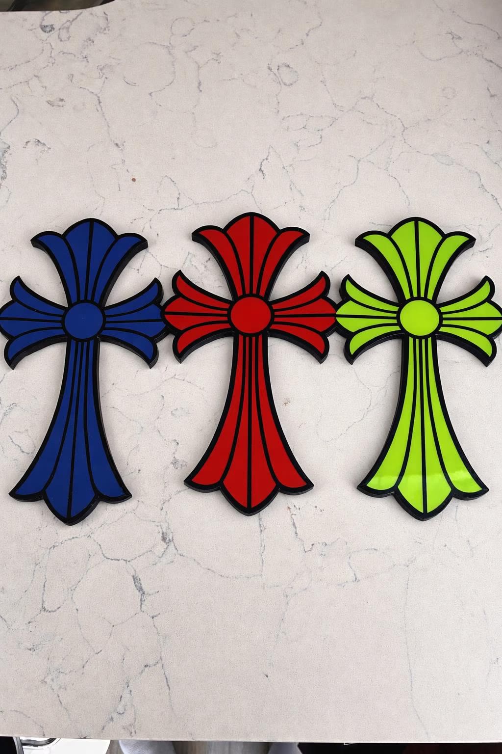 Big Cross bundle — three crosses, blue, red and green, on a white wall.
