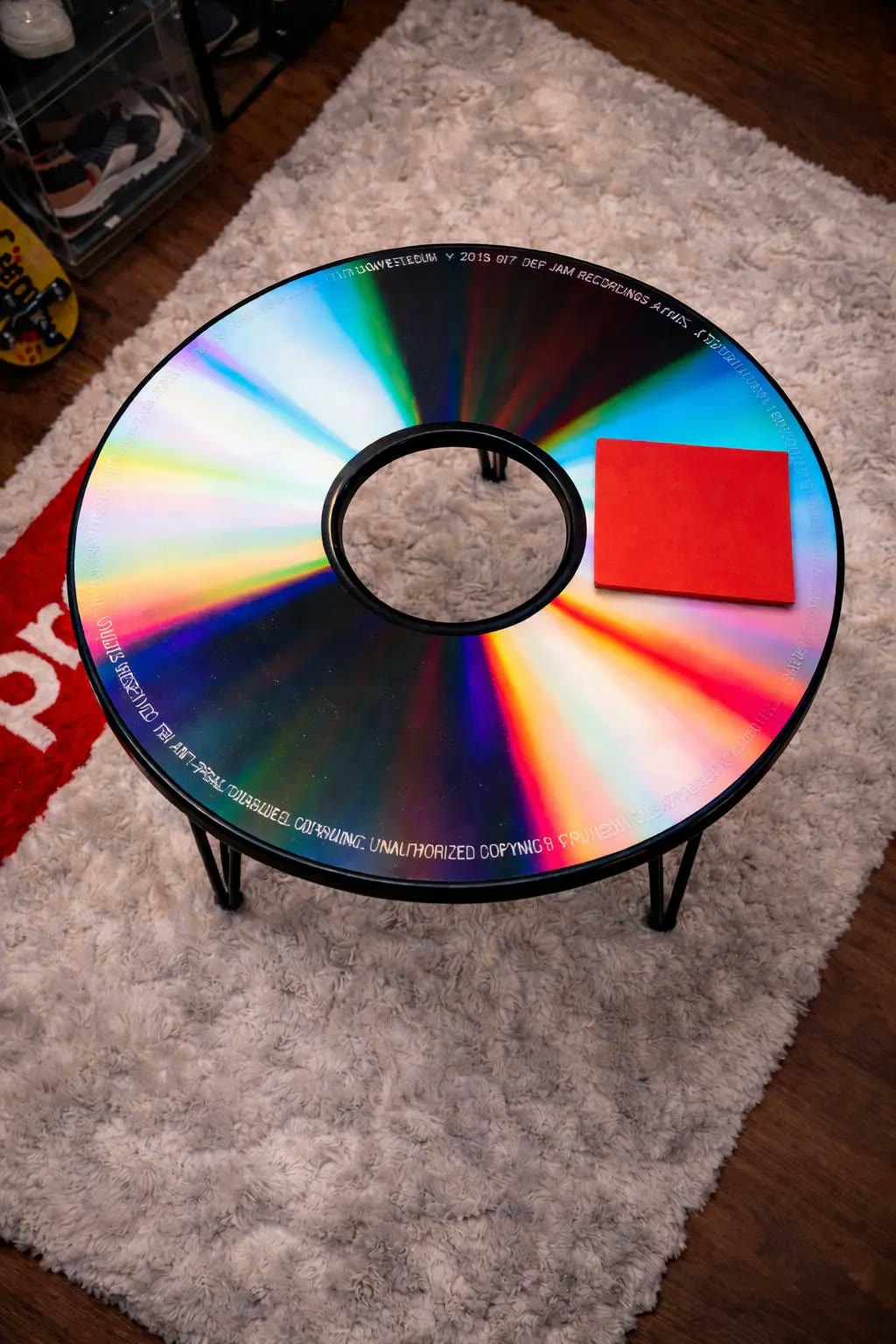 Vintage CD disc Table — a round iridescent CD-surface table, on a pale rug.